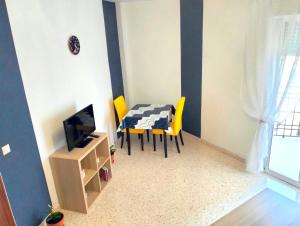 a dining room with a table and yellow chairs at Studio Nova in Priego de Córdoba