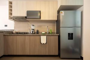 a kitchen with a stainless steel refrigerator and cabinets at Modern apartment - 10 Min to City Center in Cusco