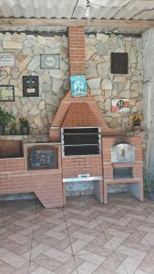 a brick oven in front of a stone wall at Chácara do vovô kiko in Santana de Parnaíba +1 photo