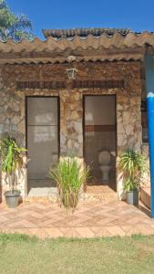 a stone building with two doors and a toilet at Chácara do vovô kiko in Santana de Parnaíba