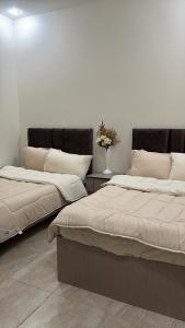 two beds sitting next to each other in a room at Sweet home in Hail +8 photos