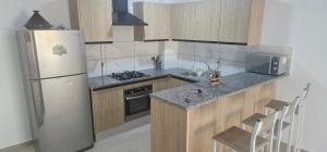 a small kitchen with a refrigerator and a sink at RESIDENCE FEDI un salon et deux chambres in Monastir