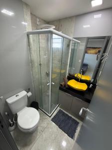 een badkamer met toilet en glazen douche bij Confort Flat Campina Grande in Campina Grande