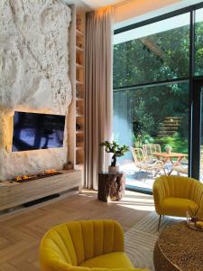 a living room with a fireplace and yellow chairs at LUXURY LOFT with LOVE SEASIDE self check-in in Klaipėda +33 photos