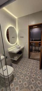 une salle de bain avec toilettes, lavabo et miroir dans l'établissement Villa da Serra Studio com ar condicionado Quente/frio, à Conceição da Ibitipoca