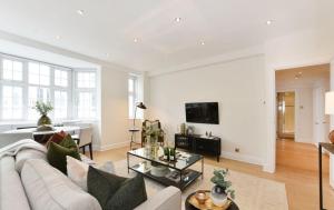 a living room with a couch and a table at Estatesmen Harrods Knightsbridge Apartment in London
