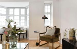a living room with a chair and a table at Estatesmen Harrods Knightsbridge Apartment in London