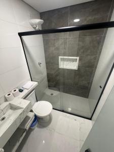 a bathroom with a shower and a toilet and a sink at Hotel Haven Guarulhos in Guarulhos