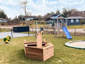 a playground with a wooden box in the grass at 20 person holiday home in Glesborg in Glesborg