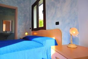 a bedroom with a blue bed and a window at Santa Maria in Cittadella del Capo