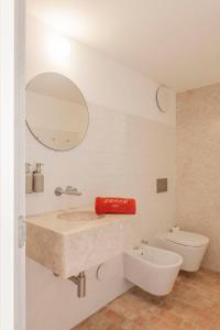 a bathroom with a sink and a toilet and a mirror at Danna Portuguese Design House Porta 10 in Tavira
