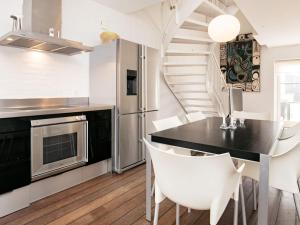 a kitchen with a dining table and a spiral staircase at 4 star holiday home in Skagen in Skagen