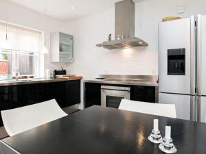 a kitchen with a black table and a refrigerator at 4 star holiday home in Skagen in Skagen
