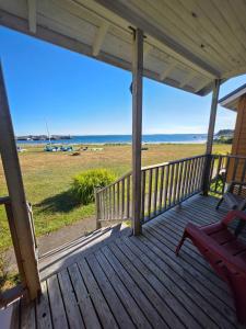 a wooden porch with a bench and the beach at Hunts Point 1-BR Coastal Retreat - Cottage # 6 in Summerville Centre