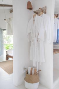 a room with white clothes hanging on a wall at Vila Oyá - Praia de Algodões in Marau