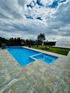 a swimming pool with a tent in the background at Quinta Paco de Lucía in Yaruqui