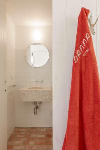 a bathroom with a sink and a red towel at Danna Portuguese Design House Porta 7 in Tavira