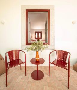 two chairs and a table in front of a mirror at Danna Portuguese Design House Porta 7 in Tavira