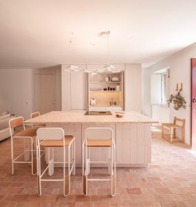 a kitchen with a large island with stools at Danna Portuguese Design House Porta 7 in Tavira
