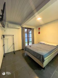 a bedroom with a bed in a room with a window at Linda suíte à 300m da Praia do Pequeá no Saco da Capela in Ilhabela