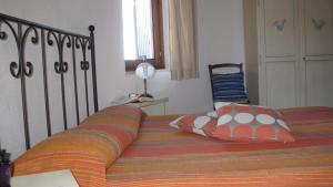 a bedroom with a bed with an orange blanket and a lamp at B&B Supramonte in Orgosolo