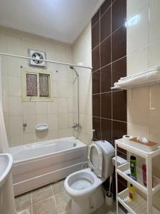 a bathroom with a toilet and a tub and a sink at شقق فندقية هادئة بحي السلامة in Jeddah