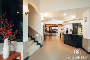 um lobby de um hotel com duas pessoas de pé no balcão em Incheon Airporthotel Airstay em Incheon