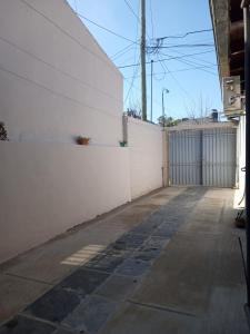 an empty driveway with a white wall and a fence at Monoambiente Blanca in Concordia +8 photos