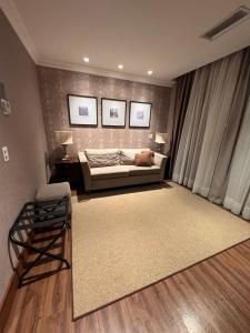 a living room with a bed and a couch at Buona Vitta Gramado in Gramado +3 photos