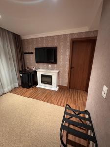 a living room with a fireplace and a flat screen tv at Buona Vitta Gramado in Gramado