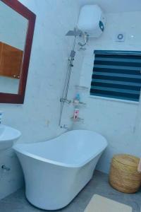 a bathroom with a white tub and a sink at Home of Grace, Abeokuta in Abeokuta +17 photos