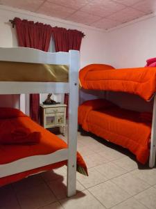 a room with two bunk beds with orange sheets at Mi casa en tanti casa 26 in Tanti