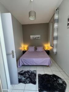 a bedroom with a bed with purple sheets and pillows at La Parenthèse Enchantée Avignon in Avignon