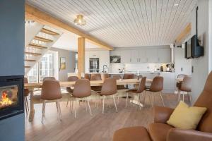 a living room with a dining room table and a fireplace at 266-Harboore-Strandvejen-177-A in Harboør