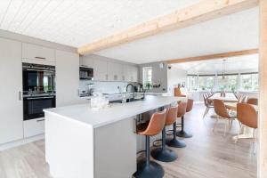a kitchen and dining room with white cabinets and a table at 266-Harboore-Strandvejen-177-A in Harboør
