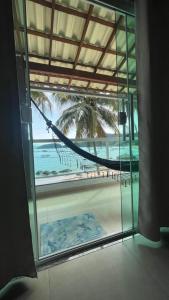 a hammock in a room with a view of a beach at Carneiro's House in Praia de Araçatiba