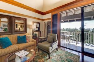 a living room with a couch and a balcony at Poipu Beach Bungalow in Koloa