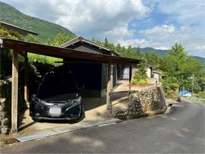 a car parked in a garage next to a house at Cottage Kirihata in Tanabe