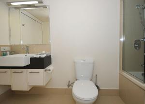 a bathroom with a toilet and a sink and a mirror at Ramada by Wyndham Hervey Bay in Hervey Bay