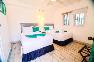 two beds in a room with green and white at Hotel Casa Turquesa in Flores +39 photos