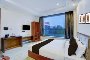 ノイダにあるHotel O Expo Mart Ansal Golf Link 1のベッドと大きな窓があるホテルの部屋