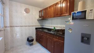 a kitchen with wooden cabinets and a refrigerator at Amoblados delicias norte chia in Chía +3 photos