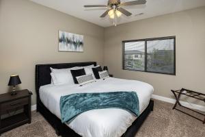 a bedroom with a bed and a ceiling fan at Stylish & Spacious, Pool, Nintendo Switch, King bed in West Des Moines