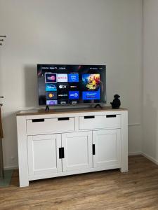 a white entertainment center with a flat screen tv on top at Stilvolle 2 Zimmerwohnung in Fellbach