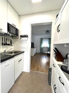 a white kitchen with a sink and a microwave at Stilvolle 2 Zimmerwohnung in Fellbach