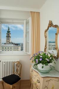 Zimmer mit einem Tisch mit einer Vase aus Blumen und einem Fenster in der Unterkunft Austria Classic Hotel Wolfinger - Hauptplatz in Linz