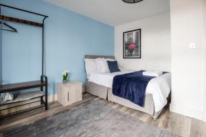 a bedroom with a bed with a blue wall at Hiltop 2Bed Apartment, Near City Centre, Sleeps 4 with Parking in Coventry