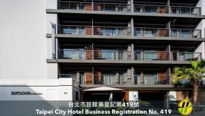 台北Simple+ 饭店的一座公寓楼,阳台上有人在座