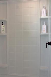 a bathroom with a shower with two bottles of soap at The Pelican Pass in Freeport +26 photos