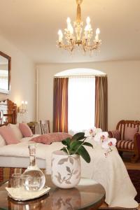 ein Wohnzimmer mit einem Bett und einem Tisch mit einer Vase in der Unterkunft Austria Classic Hotel Wolfinger - Hauptplatz in Linz
